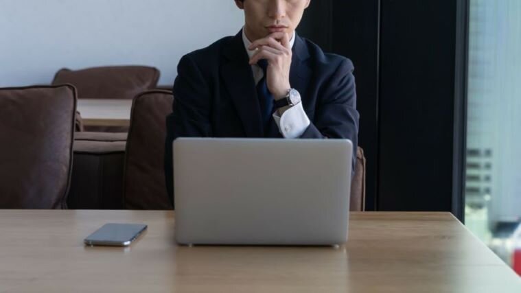 PCの前で悩む男性
