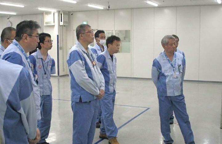 現場報告を聞く経営層と他社員の様子